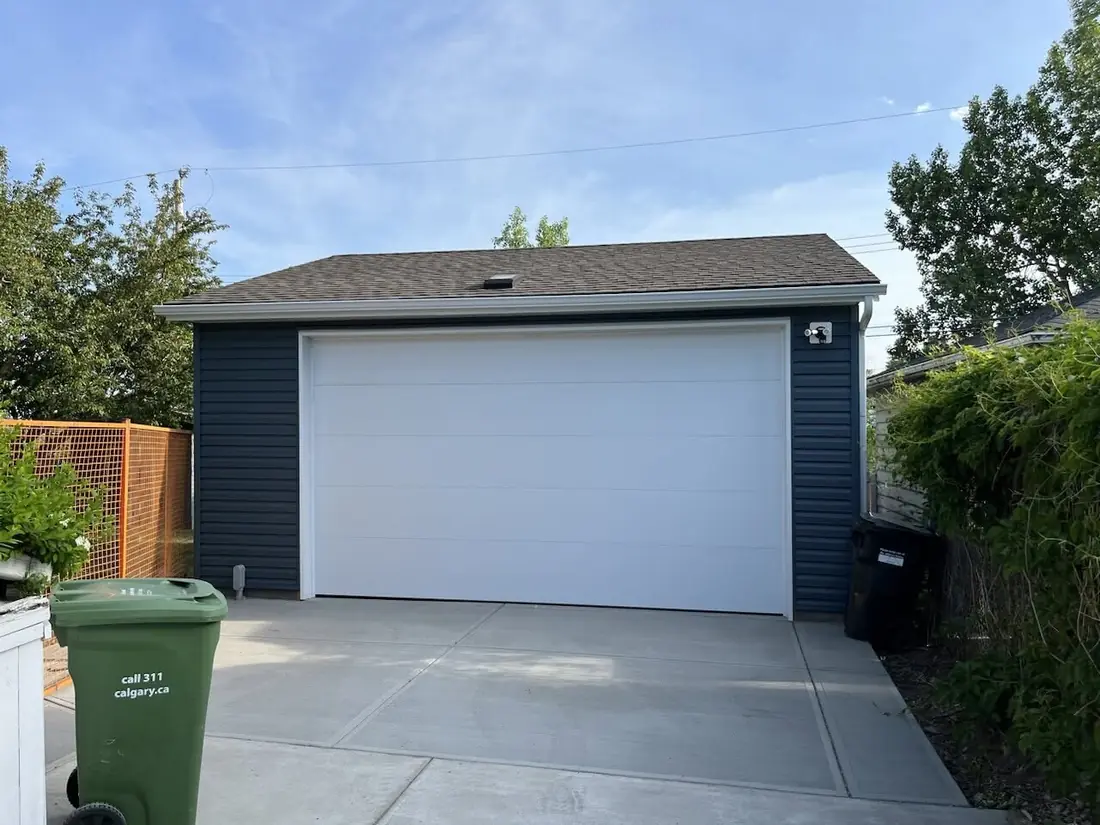 Navy siding, flush white door, a garage built by Alliance Renovations