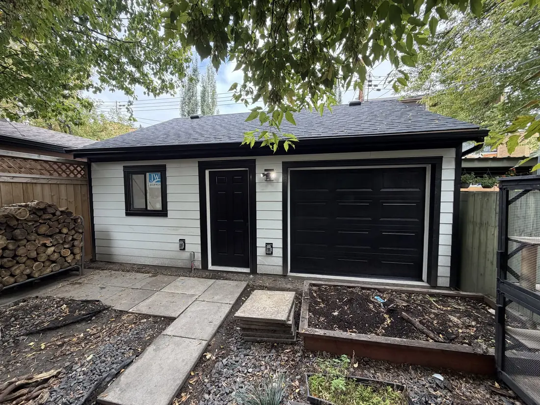 White siding, raised-panel door, a garage built by Alliance Renovations